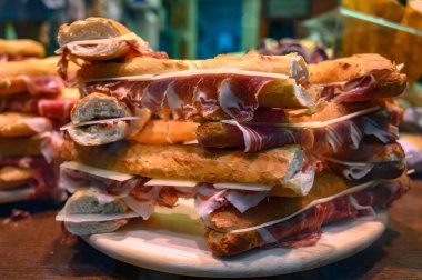 İspanyol sokak yemeği, taze pişmiş baget ekmeği dilimlenmiş İberya jamonu, yakın plan Bocadillo.