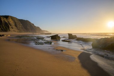 Atlantik Okyanusu 'ndaki Magoito Sahili, Sintra kıyısındaki güzel kumlu sahil gelgit sırasında, Lizbon bölgesi, Portekiz, Sintra-Cascais Doğal Parkı' nın doğal ilgi noktaları.