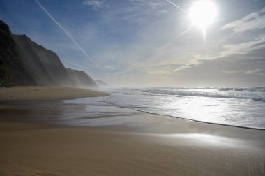 Atlantik Okyanusu 'nda gün batımında Magoito Sahili, Sintra Sahili' nde güzel kumlu plaj, Lizbon Bölgesi, Portekiz, Sintra-Cascais Doğal Parkı 'nın doğal ilgi noktaları.