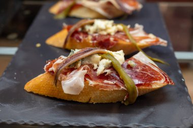 Bask ülkesinin tipik aperatifleri, pinktolar, balıklı, jambonlu ve farklı malzemeli küçük bir parça ekmek, San-Sebastian veya Bilbao, İspanya 'da barda servis edilir.