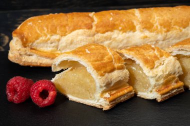 Taze fırında Hollanda baharatlı kurabiyeler, puf böreklerinden, sonbahar renklerinde bademlerle koyu taşlara yakın.