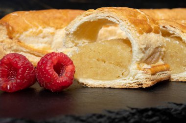 Taze fırında Hollanda baharatlı kurabiyeler, puf böreklerinden, sonbahar renklerinde bademlerle koyu taşlara yakın.