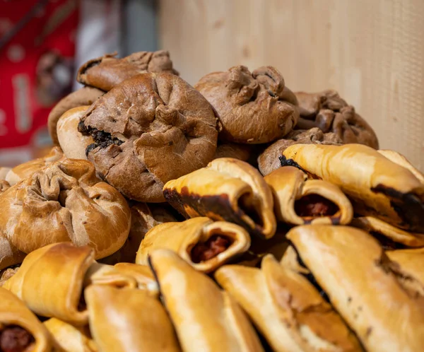 Spanish snacks and street food, baked pie empanadilla with different filling on market in San-Sebastian, Spain, close up