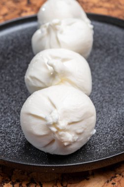 Puglia 'dan taze el yapımı İtalyan peyniri yemek, beyaz burrata topları veya mozzarella ve kremadan yapılmış burratina peyniri yemek.