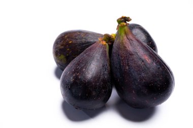 Taze, mor, organik incir meyveleri yenmeye hazır. Beyaz arka planda izole edilmiş, yakın plan.