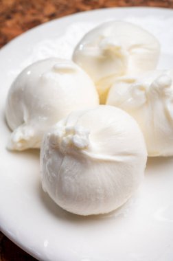 Puglia 'dan taze el yapımı İtalyan peyniri yemek, beyaz burrata topları veya mozzarella ve kremadan yapılmış burratina peyniri yemek.