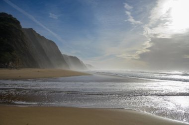 Atlantik Okyanusu 'nda gün batımında Magoito Sahili, Sintra Sahili' nde güzel kumlu plaj, Lizbon Bölgesi, Portekiz, Sintra-Cascais Doğal Parkı 'nın doğal ilgi noktaları.