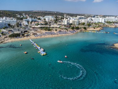 Villalar, tatil beldeleri ve Akdeniz 'deki kumlu incir ağacı plajı, Protaras, Kıbrıs Rum Kesimi yakınlarındaki mavi kristal berrak su üzerindeki hava panoramik manzarası
