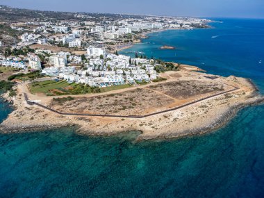 Villalar, tatil beldeleri ve Akdeniz 'deki kumlu incir ağacı plajı, Protaras, Kıbrıs Rum Kesimi yakınlarındaki mavi kristal berrak su üzerindeki hava panoramik manzarası
