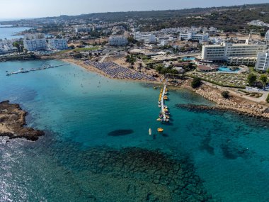 Villalar, tatil beldeleri ve Akdeniz 'deki kumlu incir ağacı plajı, Protaras, Kıbrıs Rum Kesimi yakınlarındaki mavi kristal berrak su üzerindeki hava panoramik manzarası