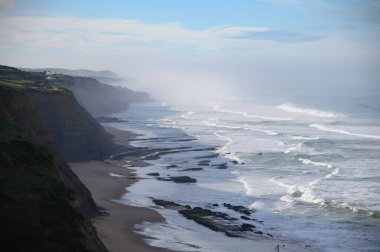 Fırtına ve yüksek dalgalar sırasında Atlantik Okyanusu 'nda Magoito Sahili Sintra Sahili' nde güzel kumlu plaj, Lizbon Bölgesi, Portekiz Sintra-Cascais Doğal Parkı 'nın doğal ilgi noktaları.