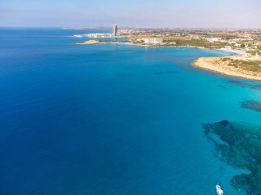 Kıbrıs 'ın Ayia Napa plajı yakınlarındaki Akdeniz' de mavi kristal berrak su üzerindeki hava panoramik manzarası. Deniz tatili.
