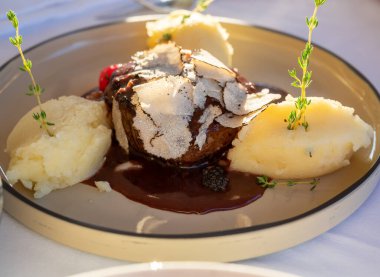Fransız restoranında taze mantarlı biftek ve patates püresi ile servis edilir.