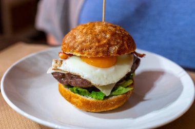 Lezzetli burger, beyaz çıtır yasak, sığır burger, yumurta, yeşil marul ve peynirle yapılır.