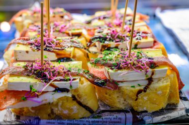 Bask ülkesinin tipik aperatiflerine sahip beyaz tahta, küçük ekmek parçaları, kabak, deniz ürünü, yumurta, peynir içeren pinkhos veya pinktos şişleri, San Sebastian veya Bilbao, İspanya 'da barda servis edilir.