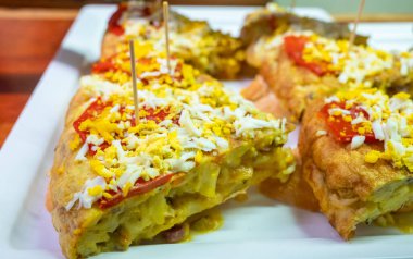 Bask ülkesinin tipik mini burgerleri, pinkotlar, yumurtalı omlet ve farklı malzemelerle birlikte küçük bir parça ekmek, San-Sebastian veya Bilbao, İspanya 'da barda servis edilir.