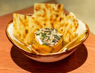 Bitki bazlı vejetaryen başlangıç yemeği, tohumlu fırında balkabağı ve glütensiz çıtır kraker. Kapalı, sağlıklı yiyecek.