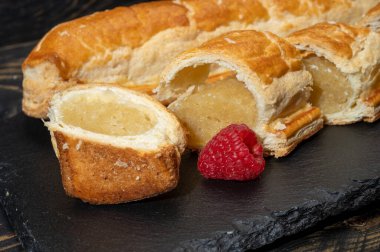 Taze fırında Hollanda baharatlı kurabiyeler, puf böreklerinden, sonbahar renklerinde bademlerle koyu taşlara yakın.