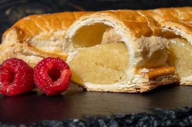 Taze fırında Hollanda baharatlı kurabiyeler, puf böreklerinden, sonbahar renklerinde bademlerle koyu taşlara yakın.