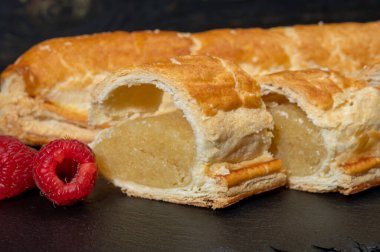 Taze fırında Hollanda baharatlı kurabiyeler, puf böreklerinden, sonbahar renklerinde bademlerle koyu taşlara yakın.