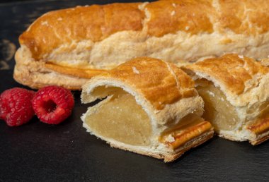 Taze fırında Hollanda baharatlı kurabiyeler, puf böreklerinden, sonbahar renklerinde bademlerle koyu taşlara yakın.