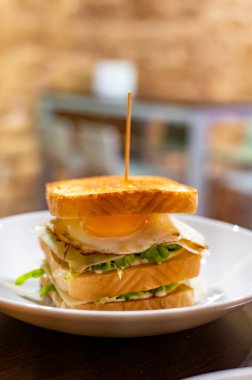 Beyaz ekmek, yumurta, yeşil marul ve peynirli vejetaryen sandviç.