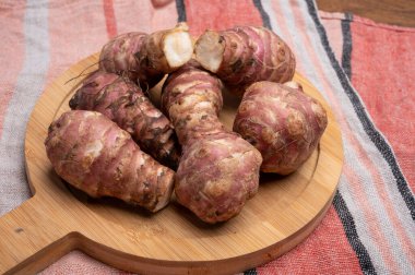 Taze pişmemiş top inambur ya da Kudüs enginar kökleri grubu yaklaşın.