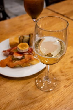 Tipik Bask Ülkesi abur cuburları, pinkotlar, şiş ya da malzemeli küçük bir parça ekmek, San Sebastian ya da Bilbao 'daki barda bir bardak txakoli şarabı ile servis edilir.