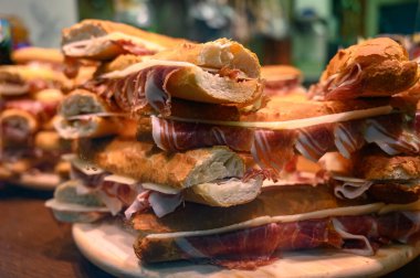 İspanyol sokak yemeği, taze pişmiş baget ekmeği dilimlenmiş İberya jamonu, yakın plan Bocadillo.