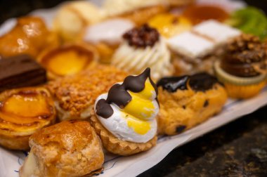 Lezzetli taze fırınlanmış renkli pastalar, kremalı turtalar ve meyveler Bilbao, Bask Bölgesi, İspanya 'daki ziyafet fırınında sergileniyor.