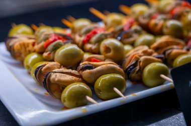 Bask ülkesinin tipik aperatifleri, küçük ekmek parçaları, deniz ürünleri, yumurta, peynir, San-Sebastian veya Bilbao, İspanya 'da barda servis edilen jamon şişleriyle kapatılıyor.