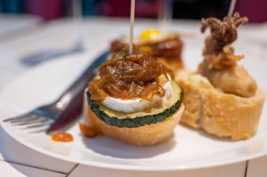 Bask ülkesinin tipik aperatiflerine sahip beyaz tahta, küçük ekmek parçaları, kabak, deniz ürünü, yumurta, peynir içeren pinkhos veya pinktos şişleri, San Sebastian veya Bilbao, İspanya 'da barda servis edilir.