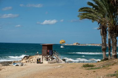 Vacation resorts on Cyprus near Paprhos with green grass, beach umbrellas, beds, beaches and palm trees, travel destination in EU, Cyprus