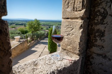 Glass of red dry wine and ruins of medieval castle of Chteauneuf du Pape ancient wine making village in France in summer clipart