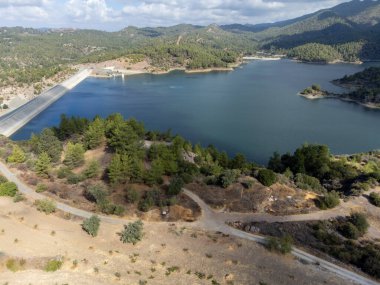 Aerial view on freshwater lake with dam for irrigation and drinking in hilly centre of dry, sunny Cyprus island