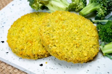 Uncooked fresh vegan and vegetarian burgers made from fresh vegetables and dried legumes and beans, ready to barbecue grill