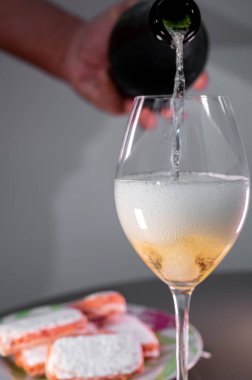 Glasses of sparkling white wine champagne or cava with bubbles and sweet dessert Reims rose biscuits on background, Reims, France