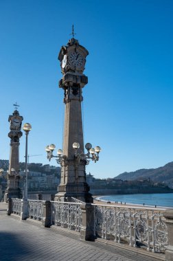 Walking on promenade along white sandy La Concha beach in central part of Donostia or San Sebastian city, Basque Country, Spain in sunny day