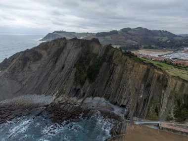 Zumaia 'nın Atlantik kıyısındaki alçak gelgitte, İspanya' nın Bask Bölgesi 'nde dik eğimli sinek jeolojik oluşumuna bakın.