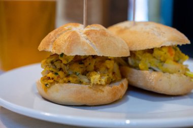 Bask ülkesinin tipik mini burgerleri, pinkholar veya pinktolar, farklı malzemelerle küçük bir parça ekmek, San-Sebastian veya Bilbao, İspanya 'da bir barda servis edilir.