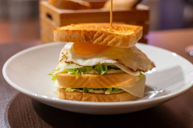 Beyaz ekmek, yumurta, yeşil marul ve peynirli vejetaryen sandviç.