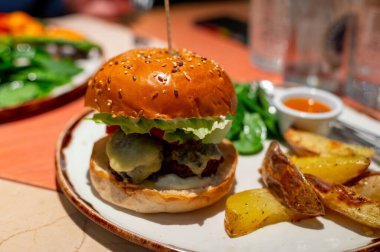 Sağlıklı yemek, organik vejetaryen burger, sebze tabanlı falafel topları, vegan peyniri, yeşil marul ve fırında patates.