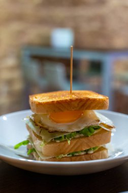 Beyaz ekmek, yumurta, yeşil marul ve peynirli vejetaryen sandviç.