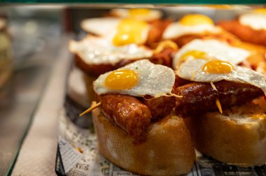 Bask ülkesinin tipik aperatifleri, küçük ekmek parçaları, deniz ürünleri, yumurta, peynir, San-Sebastian veya Bilbao, İspanya 'da barda servis edilen jamon şişleriyle kapatılıyor.