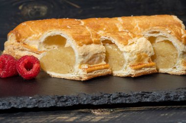 Taze fırında Hollanda baharatlı kurabiyeler, puf böreklerinden, sonbahar renklerinde bademlerle koyu taşlara yakın.