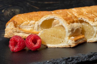 Taze fırında Hollanda baharatlı kurabiyeler, puf böreklerinden, sonbahar renklerinde bademlerle koyu taşlara yakın.