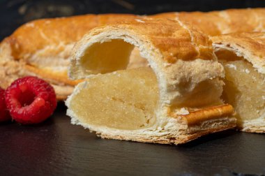 Taze fırında Hollanda baharatlı kurabiyeler, puf böreklerinden, sonbahar renklerinde bademlerle koyu taşlara yakın.