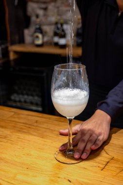 Pouring of txakoli or chacoli slightly sparkling very dry white wine produced in Spanish Basque Country in typical pinchos bar in old part of San Sebastian or Donostia, Spain
