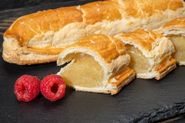 Taze fırında Hollanda baharatlı kurabiyeler, puf böreklerinden, sonbahar renklerinde bademlerle koyu taşlara yakın.