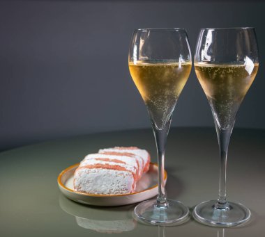 Glasses of sparkling white wine champagne or cava with bubbles and sweet dessert Reims rose biscuits on background, Reims, France
